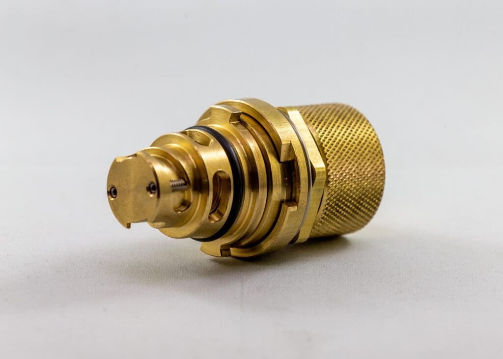 a gold metal object with a round cap Paccar 2023 Plug 2